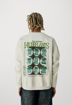 Off-white sweatshirt featuring a graphic of nine potted plants in green, with "HOUSEPLANTS" text and a phrase underneath. Ribbed cuffs.