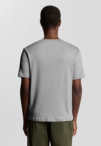 Grå kortærmet T-shirt lavet af en bomuldsblanding, med rund hals og en afslappet pasform. Glat tekstur uden synlige mønstre eller accenter.
