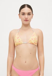 Trokutasti bikini gornji dio u žutom cvjetnom uzorku s ružičastim detaljima; podešive naramenice i nabrana tekstura. Ružičasti rebrasti bikini donji dio.