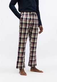 Rutig pyjamasbyxor i beige, marinblå och röd. Elastisk midja med dragsko, två sidofickor och rak passform. Mjuk textur.