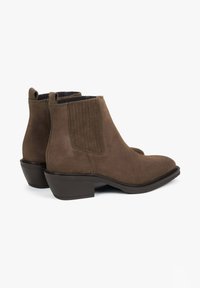 Brązowe botki zamszowe z elastycznymi panelami po bokach, szpiczastym noskiem i niskim blokowym obcasem, o gładkiej fakturze i prostych liniach.