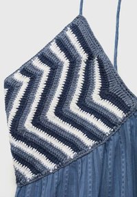Crochet top dress featuring a chevron pattern in navy and white, with a flowy blue textured lower section and adjustable straps.