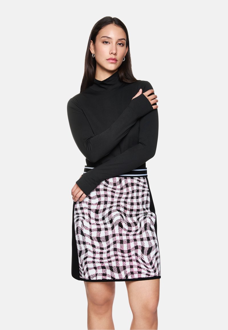 Schwarzes langärmliges Oberteil mit enganliegendem Design; karierte Röcke in Schwarz, Weiß und Pink; insgesamt schlanke Silhouette mit kontrastierenden Texturen.
