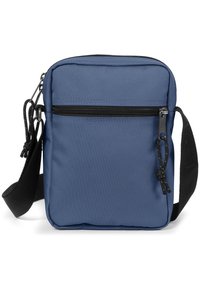 Borsa a tracolla blu in tessuto con tasca frontale con zip, tracolla nera regolabile e una superficie liscia. Le dimensioni sono compatte e rettangolari.