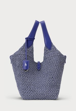 Bolsa de tote de tela azul tejida con un acabado texturizado, acentos de cuero, asas dobles y una pequeña etiqueta de cuero adjunta con un logotipo.