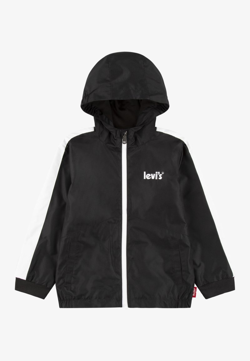 Schwarze Windbreaker-Jacke mit Kapuze, mit weißen Seitenstreifen, Reißverschluss vorne und Logo auf der Brust. Weiches, leichtes Material.