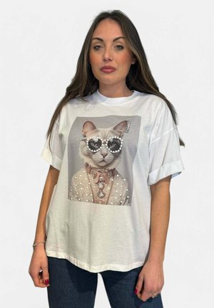 T-shirt bianco con una grafica di un gatto che indossa occhiali da sole, adornato con perle e un collare decorativo. Tessuto morbido, vestibilità comoda.
