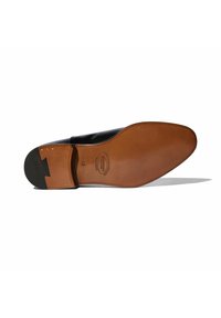 Suela de zapato de cuero negro con un inserto de cuero marrón, que presenta un acabado liso, bordes redondeados y un grabado del logo en la parte inferior.
