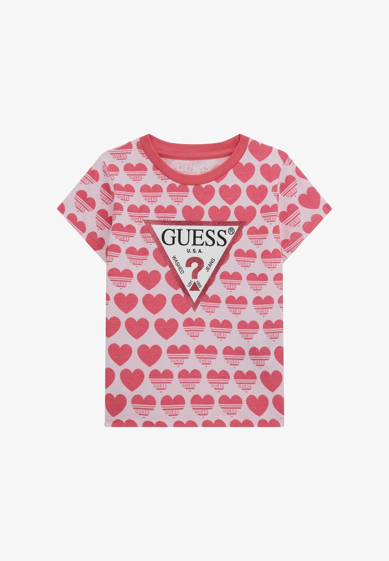 T-shirt in cotone rosa con maniche corte, caratterizzato da un motivo a cuori e un logo GUESS triangolare al centro. Il colletto è a costine.