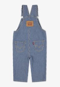 Salopette en denim à rayures bleues avec bretelles réglables, deux poches avant et une étiquette en cuir brun. Des détails de couture contrastants sont visibles.