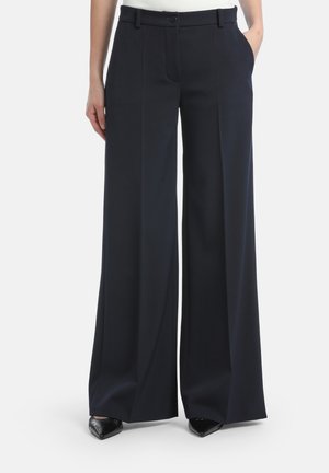 Wijduitlopende broek in donkerblauwe stof, met een hoge taille, voorzakken en een getailleerde snit. Glad textuur en strakke lijnen.