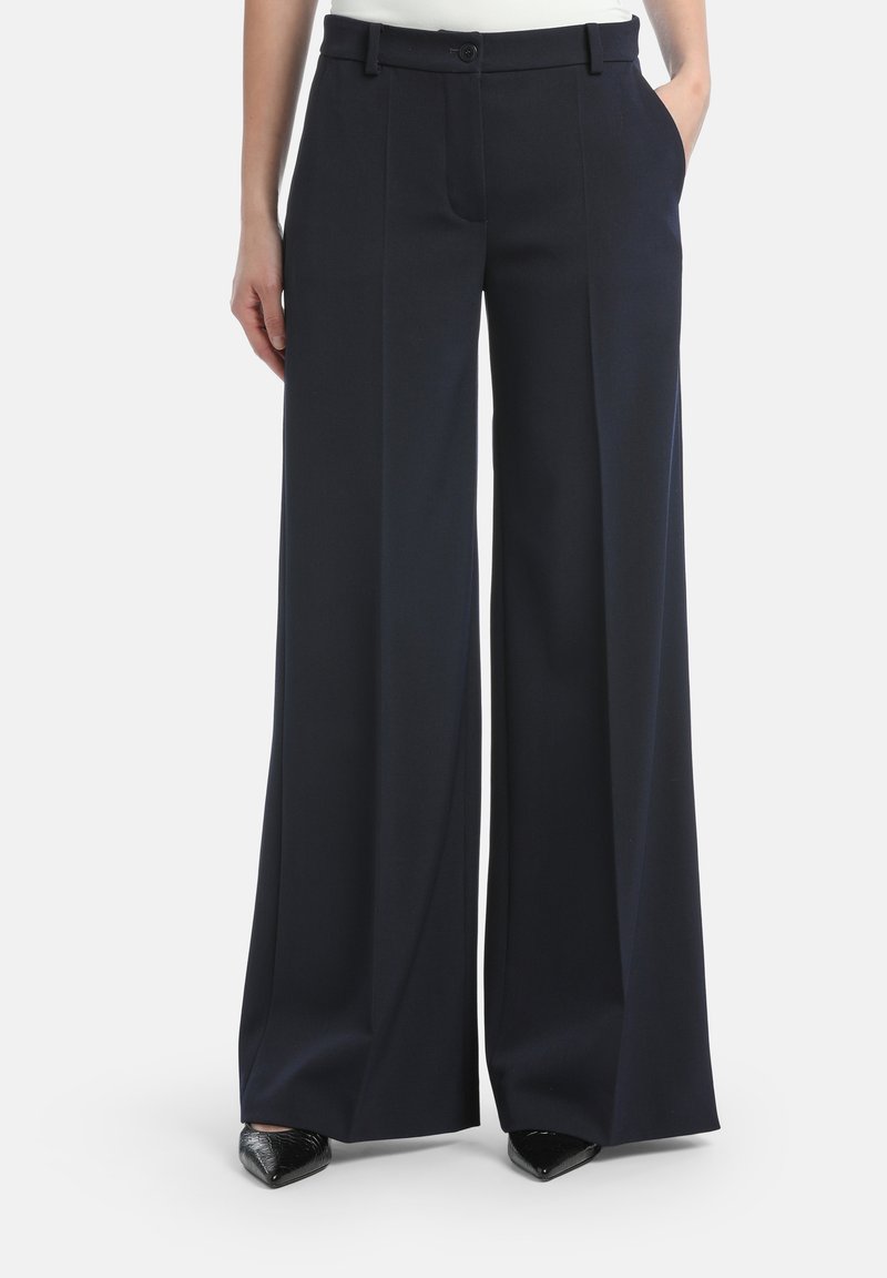 Wijduitlopende broek in donkerblauwe stof, met een hoge taille, voorzakken en een getailleerde snit. Glad textuur en strakke lijnen.