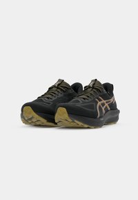 Black athletic shoes with a textured surface, featuring a raised, cushioned sole and contrasting orange accents on the side.