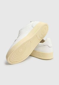 Sneaker bianche con tomaia in pelle liscia, punta rotonda e suola in gomma color crema. Presentano un branding minimale e un design con lacci.