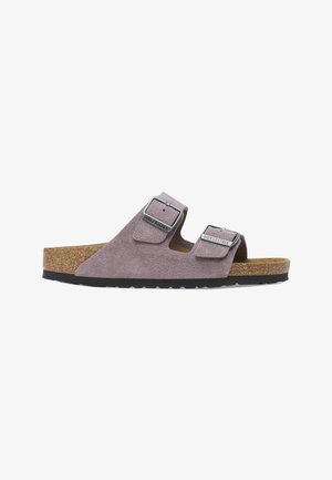 Sandalia Birkenstock de ante morado con dos hebillas plateadas ajustables, plantilla de corcho y suela de goma negra, vista lateral.