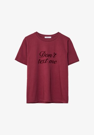 Bordo pamučna majica s crnim kurzivnim natpisom "Ne šalji mi poruke" na prednjoj strani. Kratki rukavi i okrugli izrez.