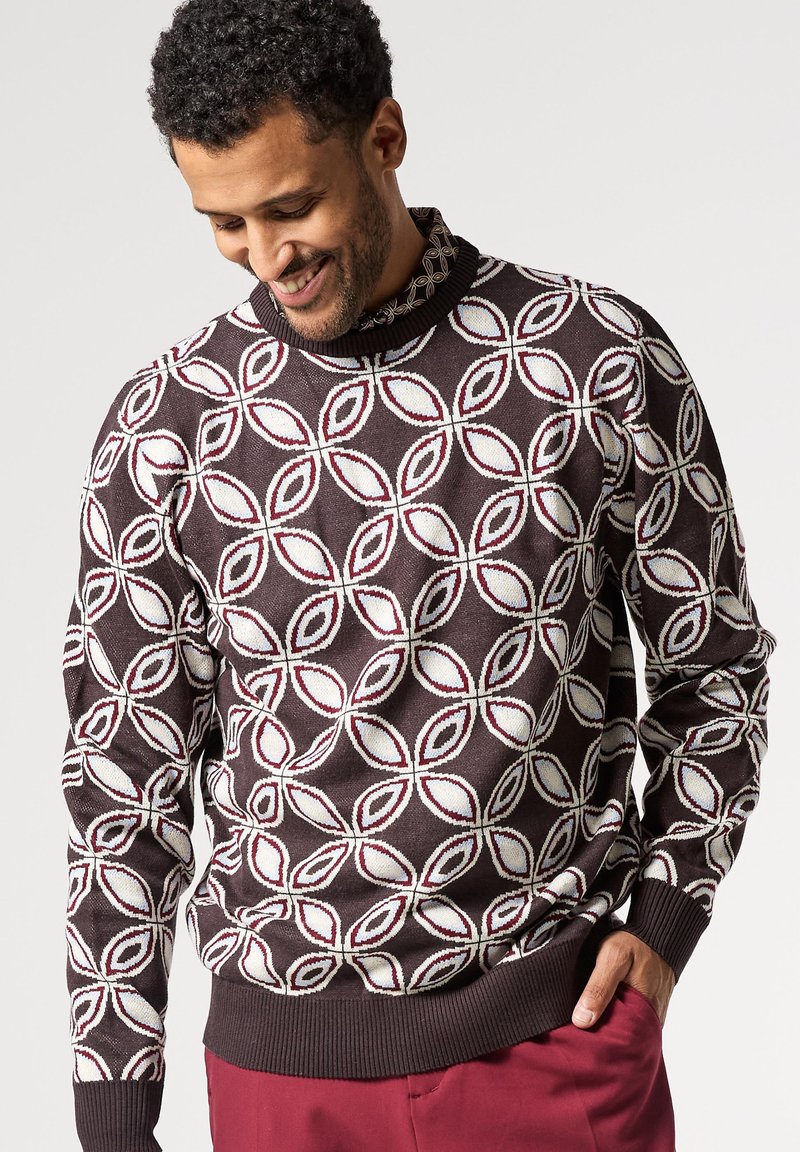 Stickad tröja med en mörkbrun bas och ett mönster av vita och burgunderfärgade blad. Inkluderar en ribbad krage och manschetter, samt en figurnära nederkant.