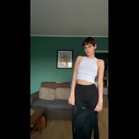 Zwarte leggings en een witte crop top. De top heeft een ronde halslijn en de leggings hebben een logo op de tailleband.