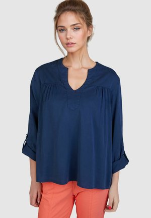 Dunkelblaue Bluse mit langen Ärmeln, V-Ausschnitt und gerafften Details. Weicher Stoff mit lockerer Passform, aufgerollten Bündchen und ohne sichtbare Muster.
