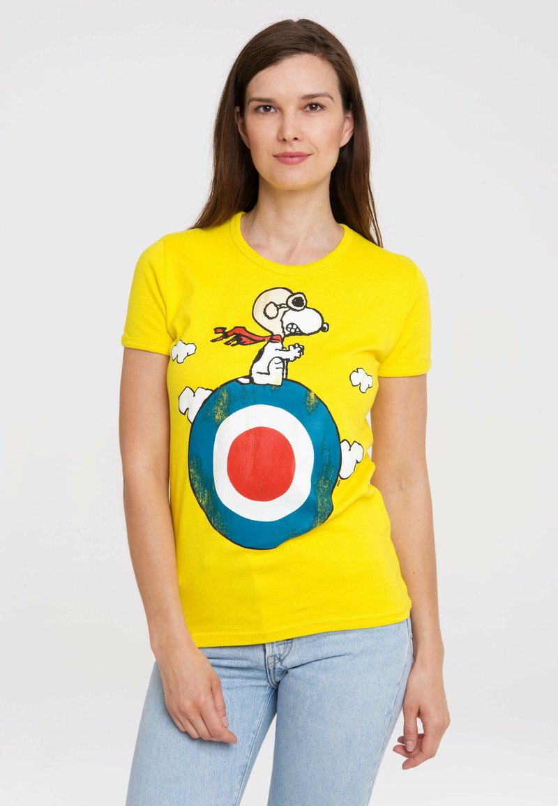 Yellow cotton T-shirt featuring a graphic of Snoopy wearing goggles on a blue and red target with cloud accents. Fitted design, short sleeves.