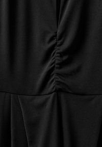 Sort kjole med blødt, glat stof med rynkning ved taljen og et plisseret skørt. Simpelt design uden synlige pynt.