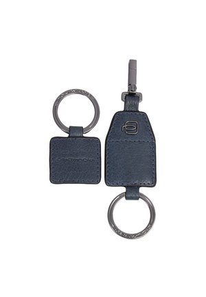 Dos llaveros de cuero azul marino con anillas metálicas, uno cuadrado y otro con forma de trapecio con un clip y logotipos grabados en el cuero y las anillas.