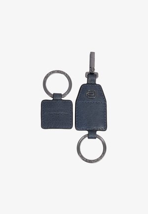 Twee navy leren sleutelhangers met metalen ringen, één vierkant en één trapeziumvormig met een clip en geperste logo's op het leer en de ringen.