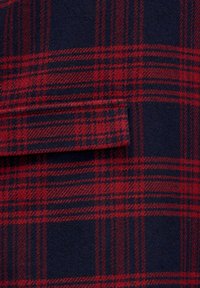 Rot und marineblaues Karomuster mit einer horizontalen Klappen-Taschenabdeckung, die zum Karo-Muster passt.