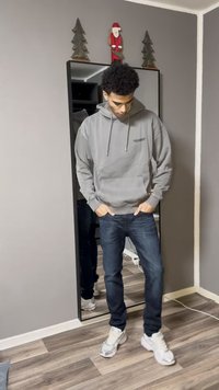 Γκρι φούτερ με κουκούλα και τσέπη μπροστά, σκούρο μπλε τζιν και γκρι αθλητικά παπούτσια. Αντίθετο εμφανίζεται σε ολόσωμο καθρέφτη.