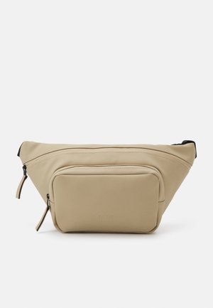 Sac banane beige avec deux compartiments zippés, poche frontale rectangulaire et sangle noire réglable sur fond blanc.