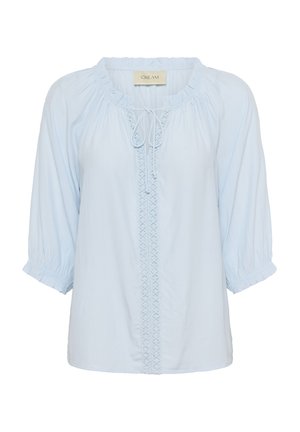 Svetlomodrá blúzka s okrúhlym výstrihom, nastaviteľnou šnúrkou a vyšívanou vertikálnou výzdobou uprostred; má balónové rukávy.