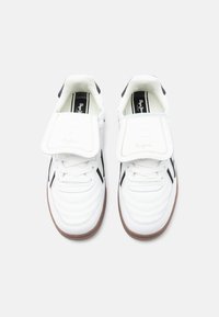 Λευκά αθλητικά παπούτσια με λείο δερμάτινο πάνω μέρος, μαύρες λεπτομέρειες, επενδυμένο κολάρο και υφασμένη λαστιχένια σόλα. Διαθέτουν αναδιπλούμενη γλώσσα.