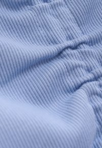 Ljusblå ribbad tyg med vertikal textur, som visar veck och mjukt fall. Mjukt material, inga synliga mönster eller metallpartier.