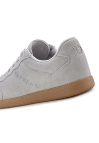 Graue Wildleder-Sneaker mit gepolstertem Kragen, Gummisohle und tonalem Nähen. Verfügt über eine eingeprägte Markenkennzeichnung an der Seite.