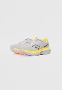 Baskets de course en maille gris clair avec un logo noir, des accents en néon jaune et orange, et une semelle blanche texturée avec des éclaboussures de couleur.