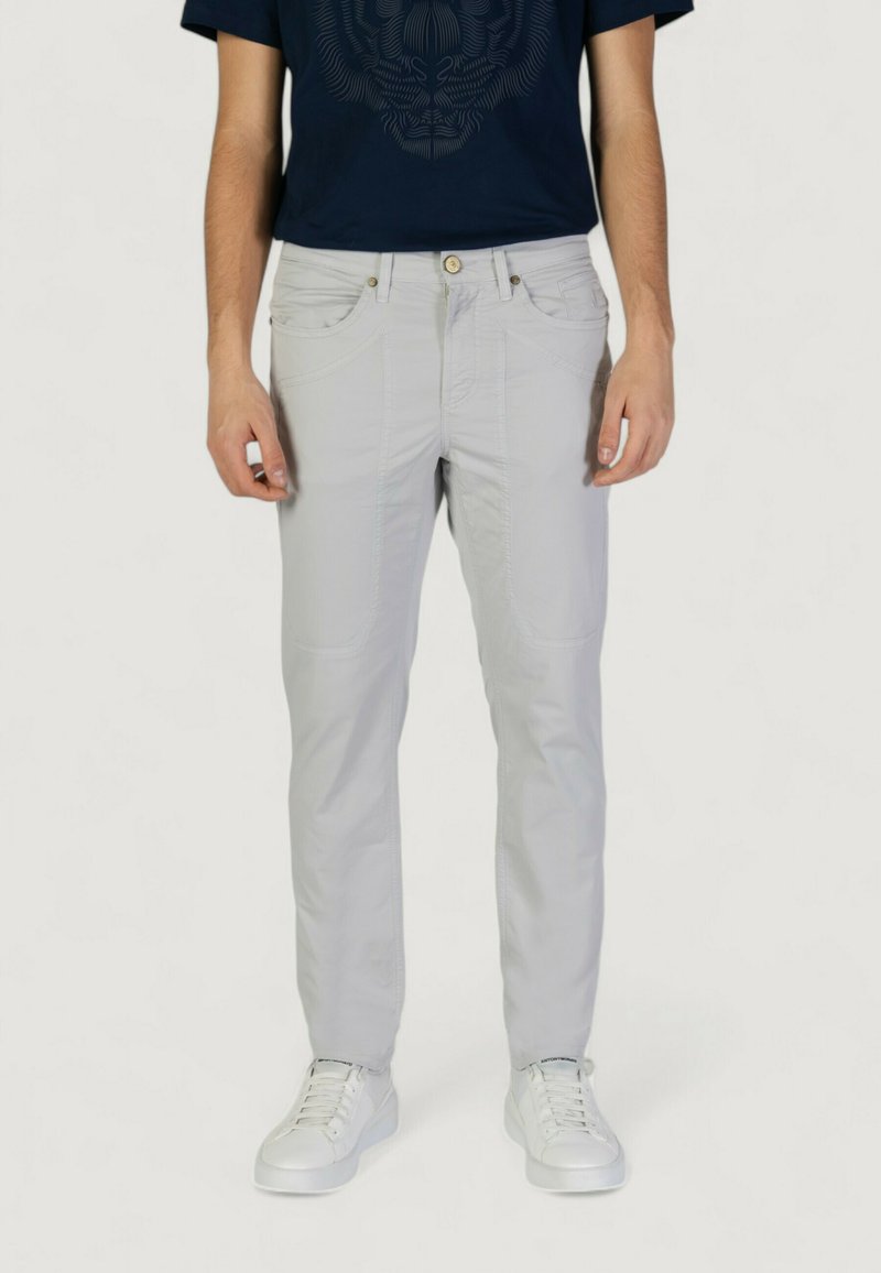 Pantalones gris claro con una textura suave, que cuentan con bolsillos insertados, detalles de costura sutil y un corte ajustado, combinados con zapatillas blancas.