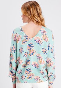 Maglione verde menta con scollo a V e motivo floreale in rosa, blu e oro. Realizzato in morbido tessuto testurizzato con maniche lunghe.