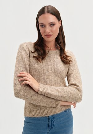 Beżowy sweter dziany z okrągłym dekoltem, długimi rękawami i prążkowanymi mankietami. Materiał ma miękkie, teksturowane wykończenie, uzupełnione dopasowanym krojem.