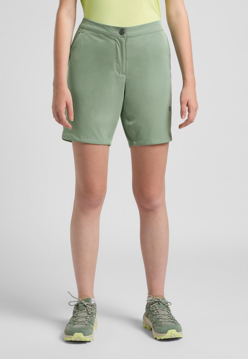Pantaloni corti verdi realizzati in materiale leggero e elasticizzato, con tasche laterali, chiusura a bottone e un orlo che arriva appena sopra il ginocchio.