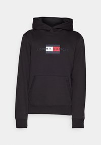 Black hoodie featuring a central logo with "TOMMY HILFIGER" text, a kangaroo pocket, and ribbed cuffs for a snug fit.