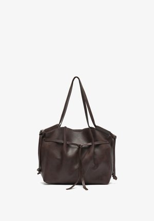 Tmavohnedá kožená taška na rameno s jemnou textúrou, sťahovaným horným okrajom a dvoma dlhými rúčkami. Na bokoch sú dekoratívne viazané detaily.