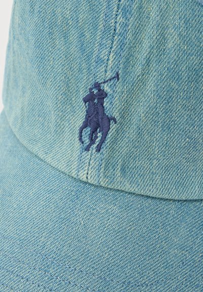 Ανοιχτό μπλε τζιν καπέλο με σκουρομπλε κεντημένο παίκτη πόλο πάνω σε άλογο, κρατώντας ένα ανεβασμένο μαλέτι στο μπροστινό πάνελ.