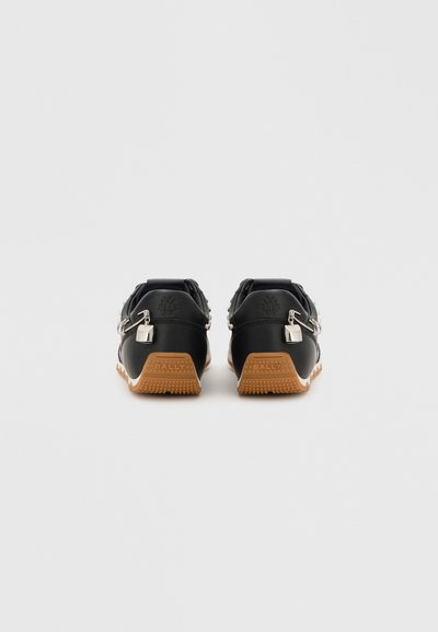 Sneaker in pelle nera con dettagli a trama nera, suole in gomma color caramello, particolari in metallo argentato e logo impresso sul tallone.