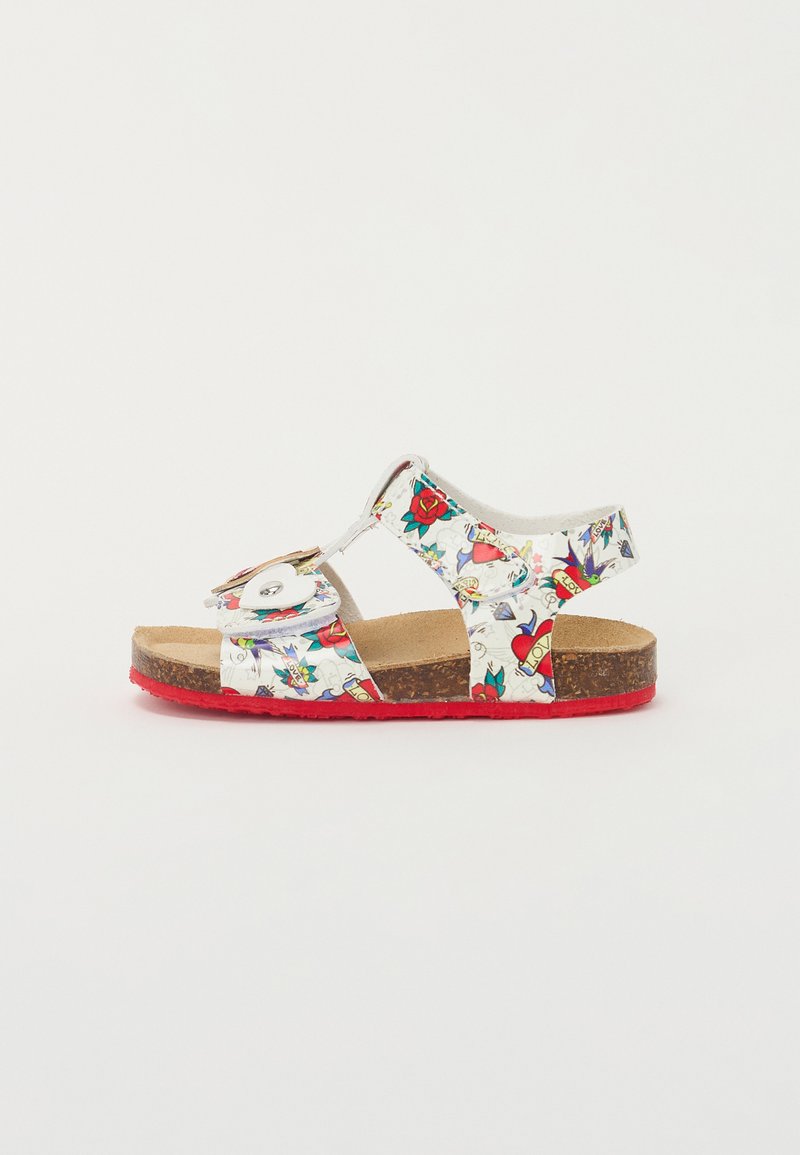 White sandals with colorful floral and heart patterns, two adjustable straps, and a red rubber sole. Cork-like footbed for comfort.