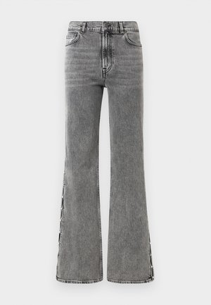 Flared black denim jeans with a high waist. Features visible stitching and side slit details, offering a textured look.