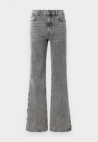 Melna denima bikses ar izplestu kāju un augstu jostasvietu. Iespējas: redzama šuvumu apdare un sānu šķēlumi, kas rada teksturētu izskatu.