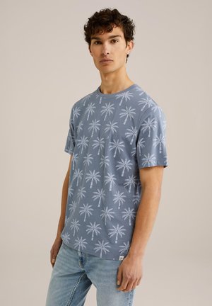 Camiseta de manga corta azul con un patrón de palmeras, hecha de algodón, con cuello redondo y corte holgado. Textura ligera y diseño casual.