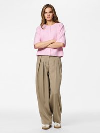 Light pink ribbed sweater with short sleeves, paired with beige wide-leg trousers. White sneakers with beige accents complete the outfit.