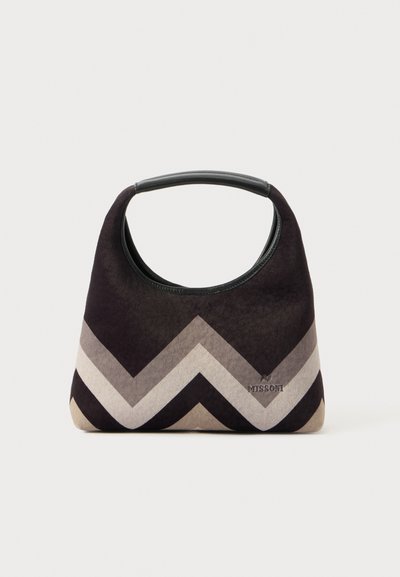Sac à main en suède noir et gris avec un motif en chevrons, anse supérieure courbée et logo de la marque en relief sur le devant.