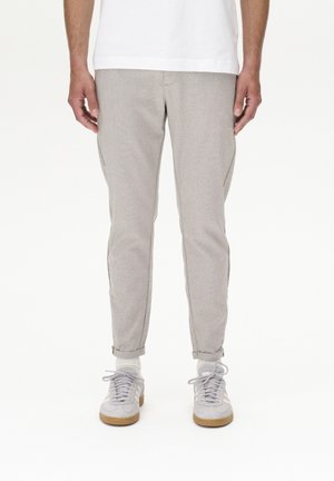 Lichtgrijze op maat gemaakte broek met een gestructureerde afwerking, slim fit, met omslag aan de onderkant en zijzakken, gecombineerd met grijze sportschoenen.